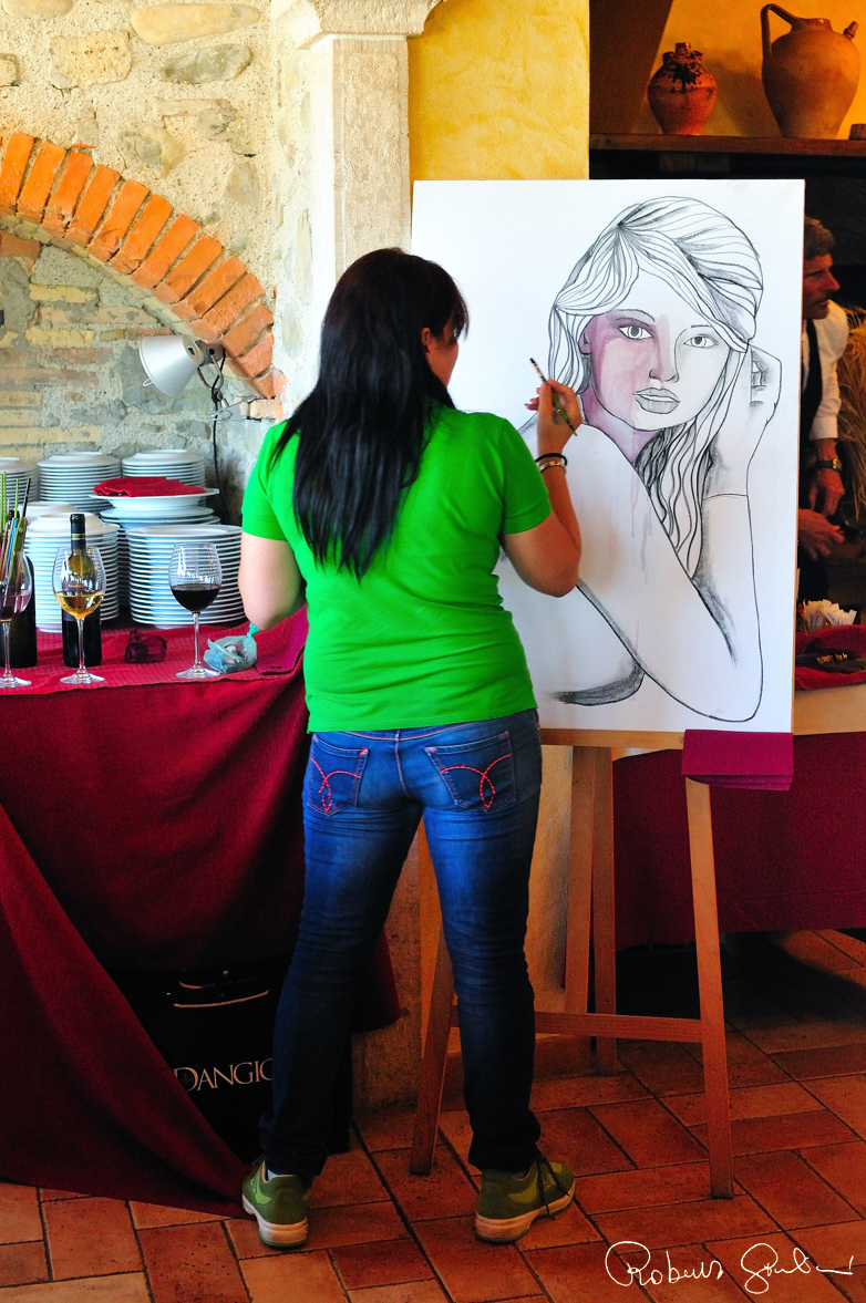 Arianna Greco effettua una dimostrazione di pittura al ristorante Il Caio