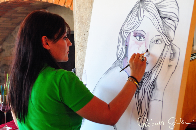 Arianna Greco effettua una dimostrazione di pittura al ristorante Il Caio