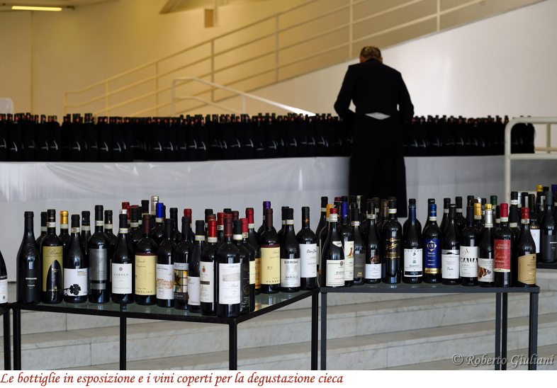 Le bottiglie in esposizione e i vini coperti per la degustazione cieca
