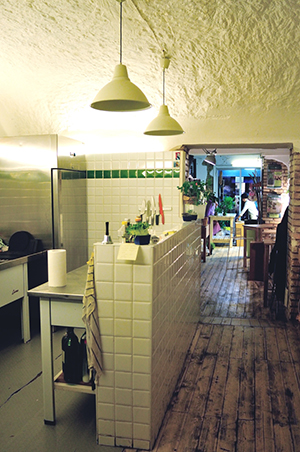 La cucina e l'ingresso alla sala con i tavoli e le sedie