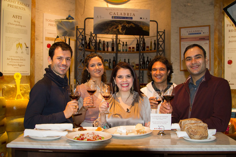 Ornella Fado brinda davanti ai piatti della cucina calabrese