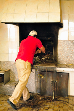 Giuseppe mentre mette la legna nel forno