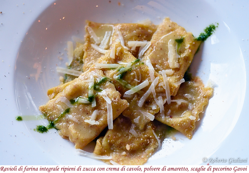 Ravioli di farina integrale ripieni di zucca con crema di cavolo, polvere di amaretto e scaglie di pecorino Gavoi