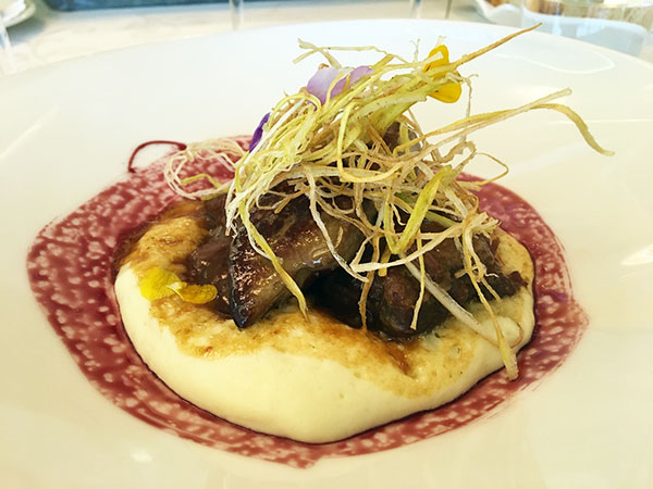 Guancialino di vitello brasato con crema di patate, fegato d’oca e porri fritti