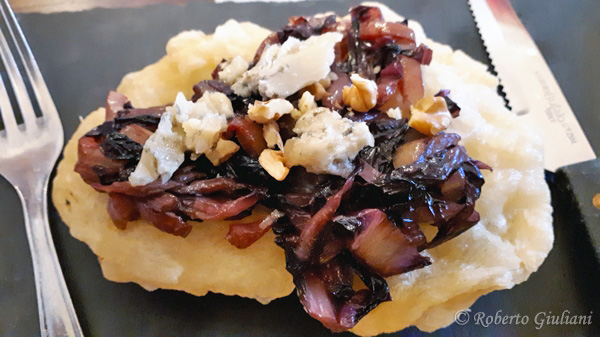 primo piano sulla Pizzetta fritta con radicchio brasato, erborinato di capra e noci