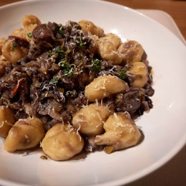 gnocchi fatti in casa, spadellati con ragù bianco di salsiccia di Muncalè, cipolla di Tropea e radicchio trevigiano