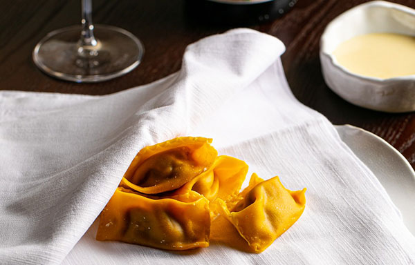 Agnolotti del plin al tovagliolo ripieni di sugo all’amatriciana, accompagnati da crema al pecorino romano DOP