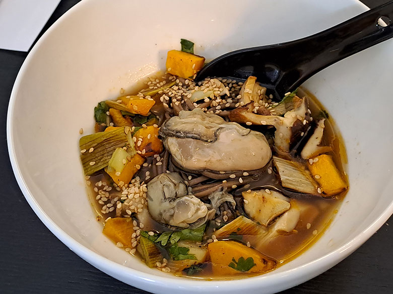 Noodles saraceni freddi, brodo vegetale tostato tiepido, zucca, funghi e cipollotto arrosto, con ostrica marinata in salsa Ponzu, zenzero e coriandolo